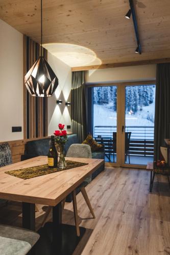 a living room with a wooden table and a couch at Alpinhotel Berghaus spa in Tux