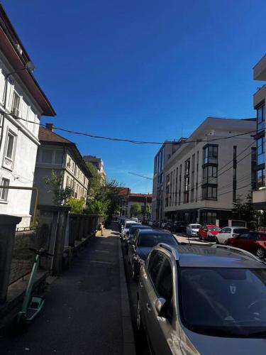uma fila de carros estacionados numa rua da cidade em Central Apartment - Book Now em Cluj-Napoca