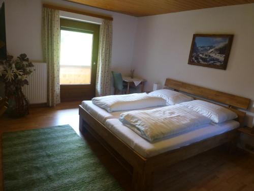 een slaapkamer met een bed en een groot raam bij Haus Bergkranz in Neustift im Stubaital