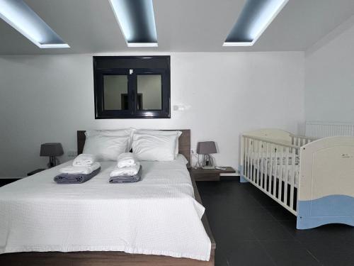 a bedroom with a bed with two towels on it at Two Bedroom Villa with Private Pool & Garden by Olivujoj in Anavyssos