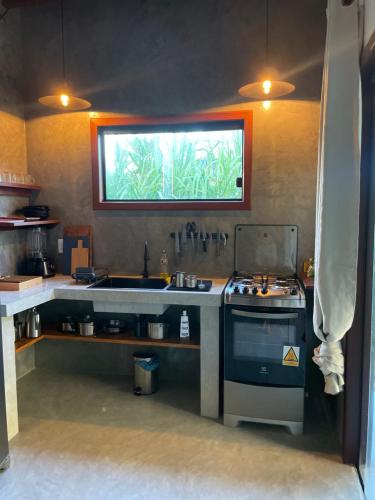 een keuken met een wastafel en een fornuis bij Casa Gemini in Ilha de Boipeba