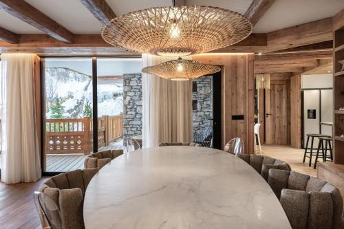 une salle à manger avec une grande table et des chaises en marbre dans l'établissement Penthouse Best View - Les Chalets COVAREL, à Val dʼIsère