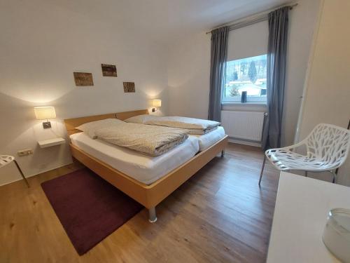 バート・ハルツブルクにあるFewo Amsbergstrasseのベッドルーム1室(ベッド1台、椅子、窓付)