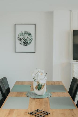a dining room table with a vase of flowers on it at Appartement T3 Hyper centre Saumur in Saumur