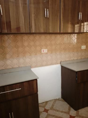 uma cozinha com armários de madeira e uma bancada em Atvam properties em Adisadel