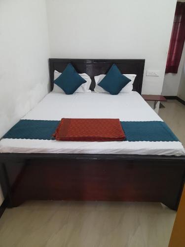 a bed with blue and red blankets and pillows on it at Aryas Residency in Coimbatore