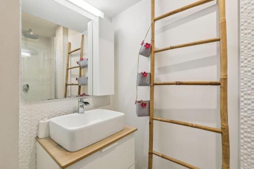 une salle de bain avec un lavabo blanc et un miroir dans l'établissement Maison d'architecte Sacré Coeur, à Paris