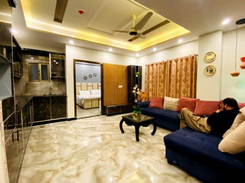 Elite Living Hotels في روالبندي: رجل يجلس على أريكة في غرفة المعيشة
