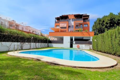 a swimming pool in a yard next to a building at ApartRincón Las Minas in Rincón de la Victoria