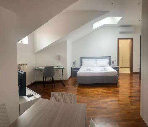 Schlafzimmer mit einem Bett, einem Tisch und einem Schreibtisch in der Unterkunft Palazzo Venezian 5 in Triest