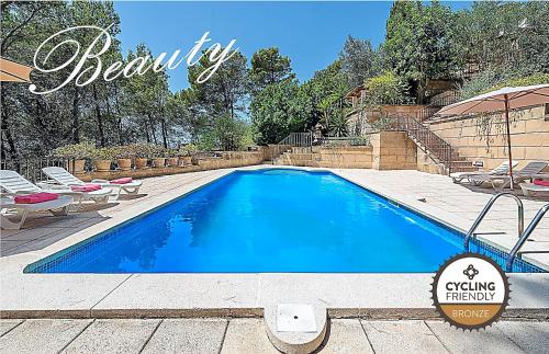 a swimming pool in a backyard with chairs and an umbrella at Holiday Villa Beauty Andratx in Capdellá