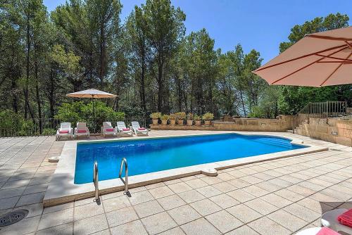 a swimming pool with two chairs and an umbrella at Holiday Villa Beauty Andratx in Capdellá