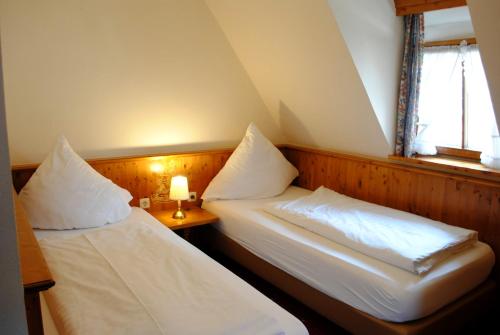 two twin beds in a room with a window at Hotel Zum Breiterle in Rothenburg ob der Tauber