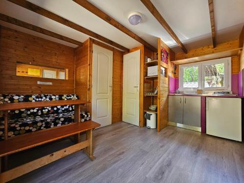 una cucina con pareti in legno e pavimenti in legno di Camp des Gorges - Camping Nature a Vallon-Pont-dʼArc