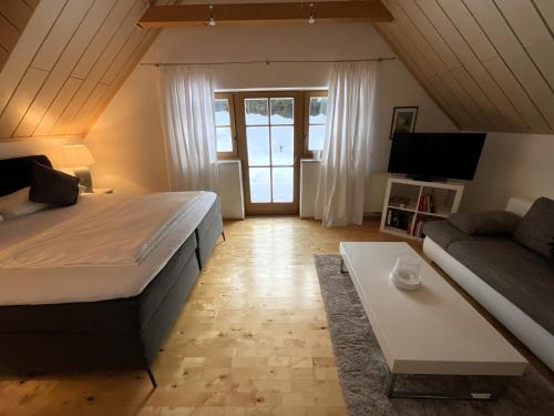 1 dormitorio con 1 cama grande y 1 sofá en Ferienwohnung Aigner, en Schellgaden