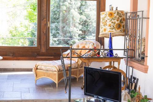 a living room with a tv and a chair and a window at Hotel Herres Alte Metzgerei in Leiwen