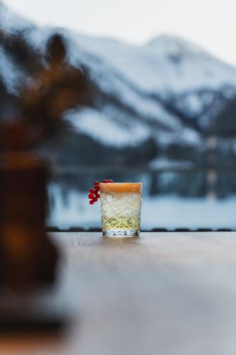 a glass with a flower in it on a table at Alpinhotel Berghaus spa in Tux