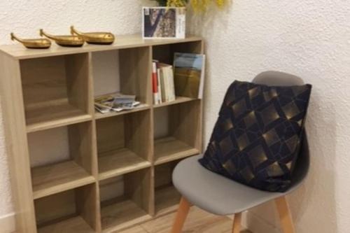 uma estante com uma cadeira na frente de uma sala em Le chant des vagues em Sète