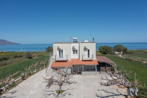 an aerial view of a house with the ocean in the background at Beachfront First-Floor Suite in Georgioupolis