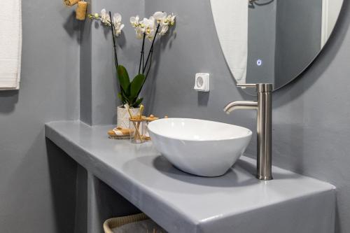 a bathroom with a bowl sink and a mirror at Salty Splash & Kyma Sirma Klima in Klima