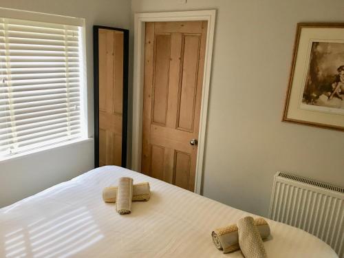 a bedroom with a bed with two towels on it at The Burrow in Wetherby