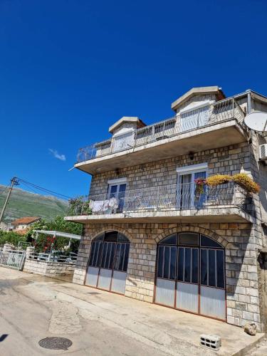 a stone building with a balcony on top of it at Apartman Sonja Trebinje in Trebinje