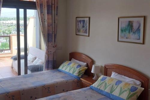 een slaapkamer met 2 aparte bedden en een raam bij 1-bedroom apartment with big terrace and ocean view in Los Cristianos in Los Cristianos