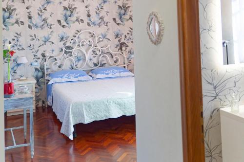 a bedroom with a bed with blue and white wallpaper at Villa Mandrioli in Cecina