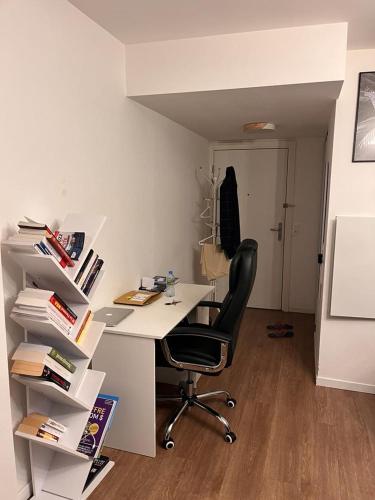 an office with a desk with a chair and books at appartement de luxe in Suresnes