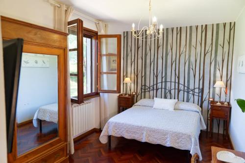 a bedroom with a bed and a mirror and a tv at Villa Mandrioli in Cecina