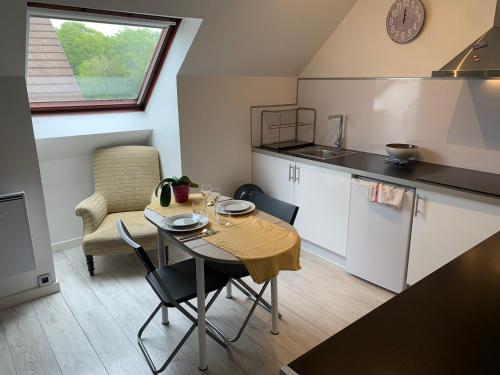 a small kitchen with a table and chairs in a room at 96 Studio - Proche Disney & Paris - Tt équipée - calme - Parking privée in Pontcarré