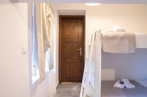 1 dormitorio con litera y puerta en Alexandras guesthouse, en Neos Panteleimonas