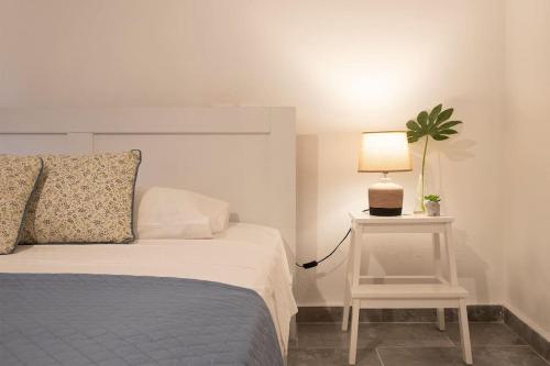 1 dormitorio con 1 cama y 1 mesa con lámpara en Alexandras guesthouse, en Neos Panteleimonas