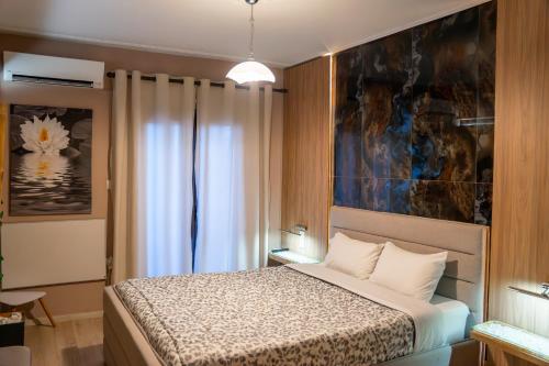 1 dormitorio con 1 cama y una pintura en la pared en Perikleous 5 Diamerisma KONDOULIS HOUSE, en Kalambaka