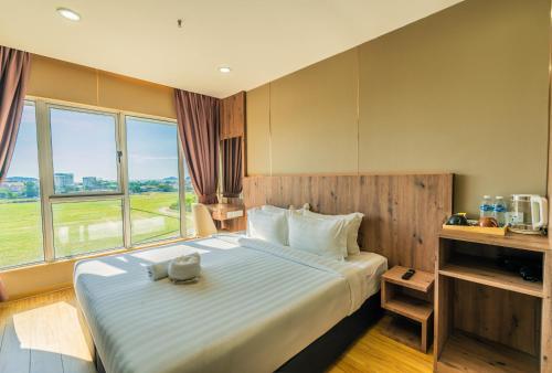 a bedroom with a large bed with a large window at KKIA HOTEL in Kota Kinabalu