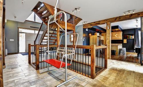 a spiral staircase in a house with a red chair at The Big Jack Chalet 33 Chemin Blanc by Les Chalets Alpins in Stoneham