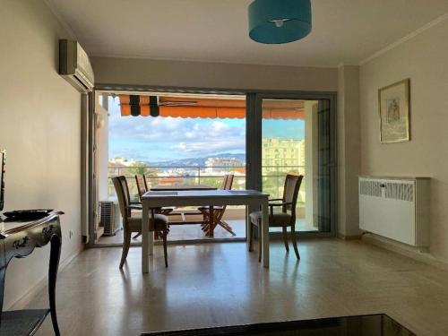 une salle à manger avec une table et des chaises et un balcon dans l'établissement Croisette and beaches. View on gardens and sea., à Cannes