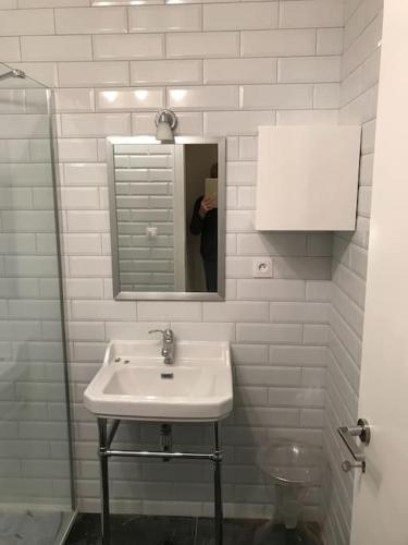 une personne prenant une photo d'un lavabo dans la salle de bains dans l'établissement Croisette and beaches. View on gardens and sea., à Cannes