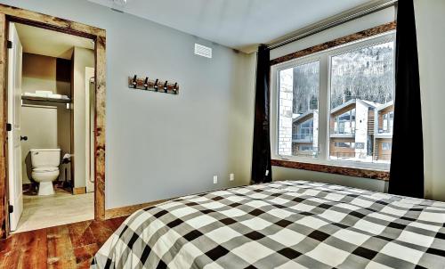 a bedroom with a bed and a window and a toilet at The Big Jack Chalet 33 Chemin Blanc by Les Chalets Alpins in Stoneham