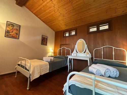 two beds in a room with a mirror at Villa del Monte di Cocco in Massarosa
