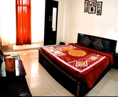 a bedroom with a bed with a red comforter at HOTEL AVI IN DALHOUSIE BANIKHET in Banikhet