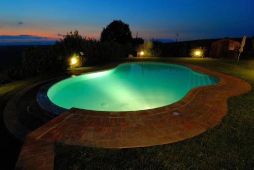 a swimming pool in a yard at night at Agriturismo Poggio delle Conche in Pitigliano