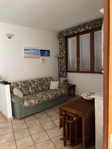 uma sala de estar com um sofá e uma mesa em Casa Castelsardo con giardino em Castelsardo