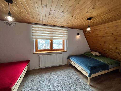 Habitación pequeña con cama y ventana en Dom w Beskidach en Zagórnik