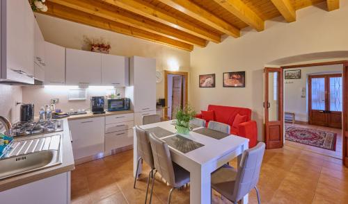 una cucina e una sala da pranzo con tavolo e sedie bianchi di CAV MOTTENO a Mandello del Lario