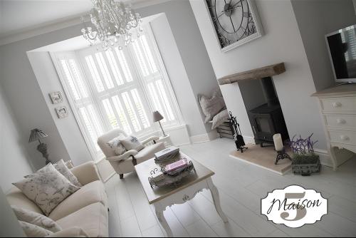 a living room with a couch and a chandelier at Maison 5 in Harrogate