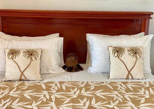 a teddy bear sitting on a bed with pillows at Spice of Ceylon in Chilaw