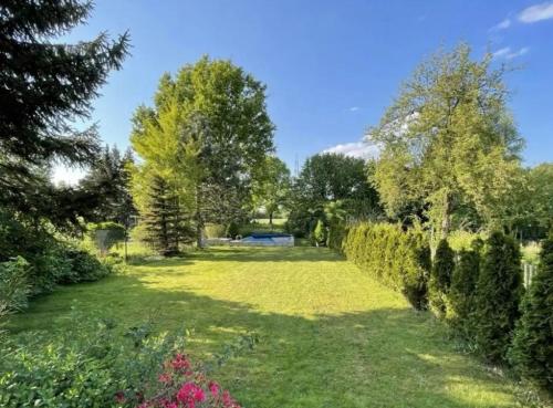 ein Garten mit Bäumen und Gras und einem Zaun in der Unterkunft Apartment bei der Palme mit Sauna Möglichkeit in Düsseldorf