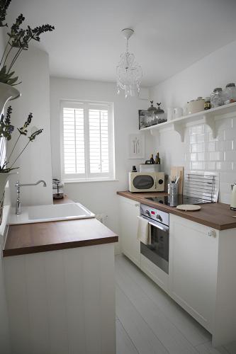 a white kitchen with a sink and a microwave at Maison 5 in Harrogate