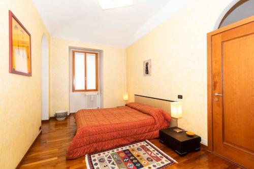 1 dormitorio con 1 cama con colcha de color naranja en Sweet Apartment nel cuore di Torino en Turín